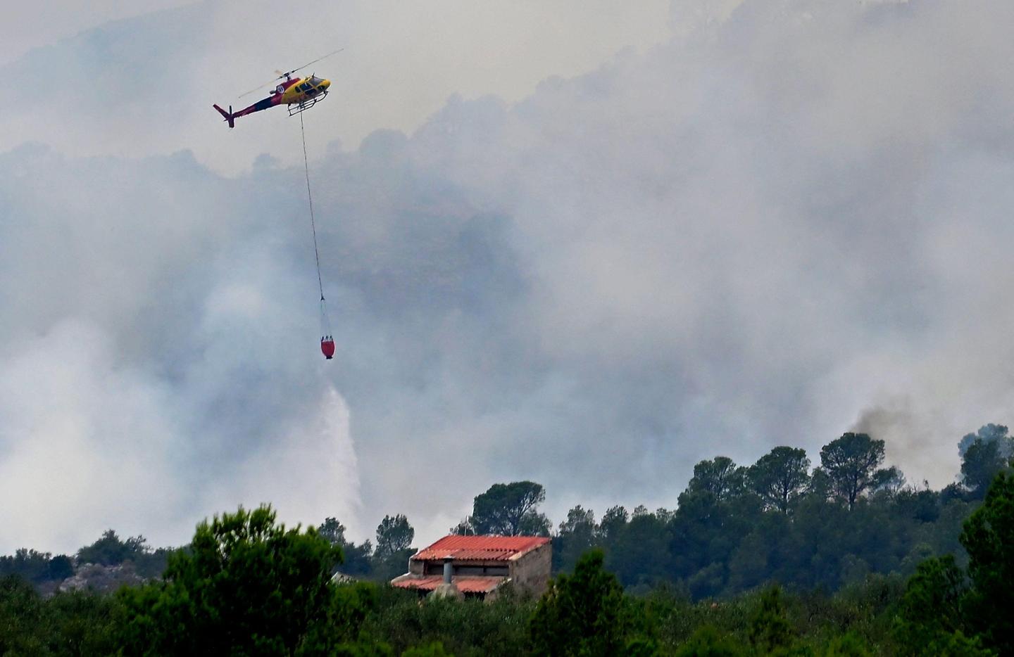 Brandweerhelikopters boven een huis nabij Pauls, vlak bij Tarragona, in de Spaanse regio Catalonië.