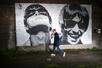 MANCHESTER, ENGLAND - AUGUST 28: An Oasis fan is photographed next to a new mural depicting Liam and Noel Gallagher of Oasis, created by Manchester street artist Pic.One.Art., on the side of the Sifters Record store in Burnage on August 28, 2024 in Manchester, England. Brothers Liam and Noel Gallagher, estranged for over 15 years, have announced they are due to reunite their band Oasis for a series of concerts next summer. The Manchester band had a string of hits in the 1990's including Wonderwall, Champagne Supernova and Don't Look Back In Anger.  (Photo by Christopher Furlong/Getty Images)