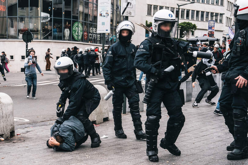 Police forces arresting someone near Central station (Gare Centrale - centralstation) in marge of a joint demonstration in Brussels against Arizona government measures on Tuesday 14 October 2025. The demonstration is a part of a national day of action to protest against the austerity of the federal Arizona government. BELGA PHOTO MARIUS BURGELMAN