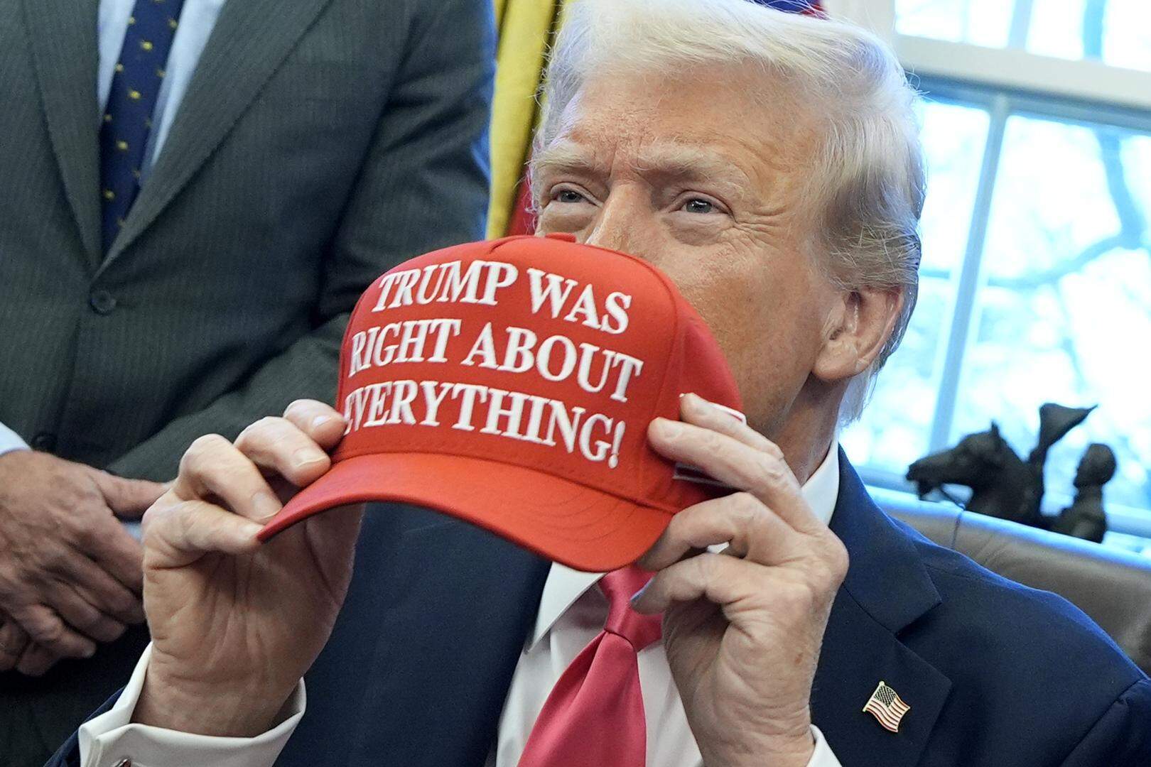 epa11924618 US President Donald Trump holds a hat reading 'Trump was right about everything' after signing executive orders in the Oval Office of the White House in Washington, DC, USA, 25 February 2025.  EPA-EFE/YURI GRIPAS / POOL world rights