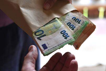 ILLUSTRATION - 03 June 2025, Bavaria, Augsburg: A person hands another person a bundle of 100 euro banknotes. Photo: Karl-Josef Hildenbrand/dpa (Photo by Karl-Josef Hildenbrand/picture alliance via Getty Images)
