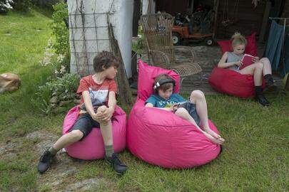 Tsjechie, Mojne, 20150508. Kinderen op een ipad, gamen en luisteren naar muziek tijdens hun akantie in de tuin. Children in the garden during holidays, listenng music and using social media. Model released. Naamsvermelding verplicht; Foto ; Sabine Joosten/Hollandse Hoogte