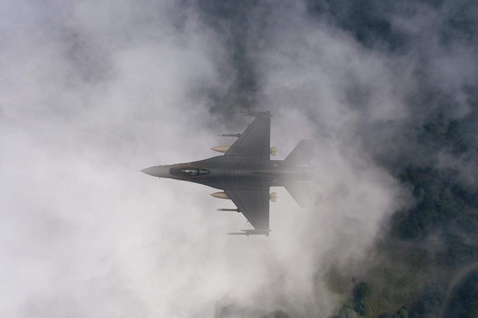 F-16 fighter jet plane flying over the clouds.