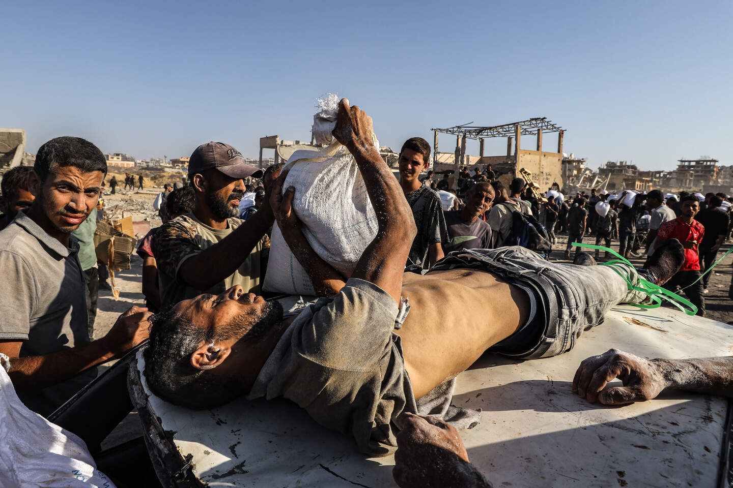 Palestijnen die bij een voedselverdeelpunt in Gaza gewond raakten, worden weggevoerd.