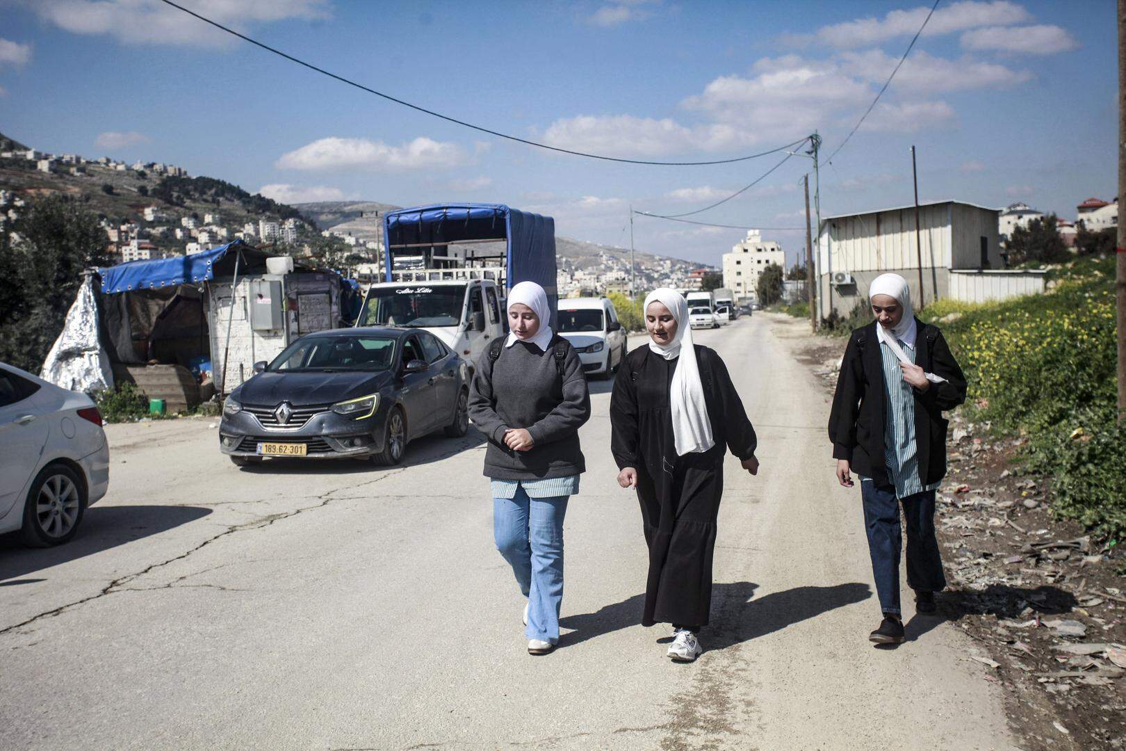 NABLUS, WEST BANK, PALESTINE - 2025/03/23: Palestinian female students cross the Israeli Awarta military checkpoint, south of Nablus in the West Bank. The Israeli government has tightened its military measures in areas under Palestinian Authority control in the West Bank, having installed over 800 checkpoints and road gates. (Photo by Nasser Ishtayeh/SOPA Images/LightRocket via Getty Images)