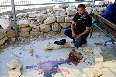 A Palestinian man looks at blood on the ground in the aftermath of a clash with an Israeli settler, at the village of Umm al-Khair, near the city of Hebron in the Israeli-occupied West Bank July 29, 2025. REUTERS/Mussa Qawasma