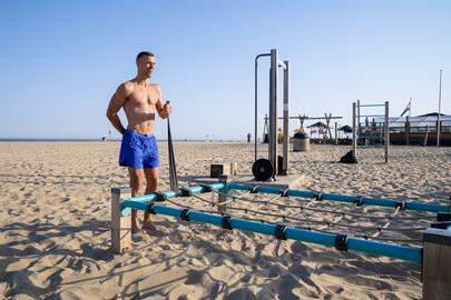 SCHEVENINGEN - Een man doet krachttraining op het strand van Scheveningen. Vanwege de hoge temperaturen heeft het KNMI code oranje afgegeven. ANP BART MAAT