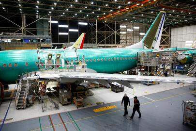 FILE PHOTO: Two workers walk under the wing of a 737 Max aircraft at the Boeing factory in Renton, Washington, U.S., March 27, 2019.  REUTERS/Lindsey Wasson/File Photo