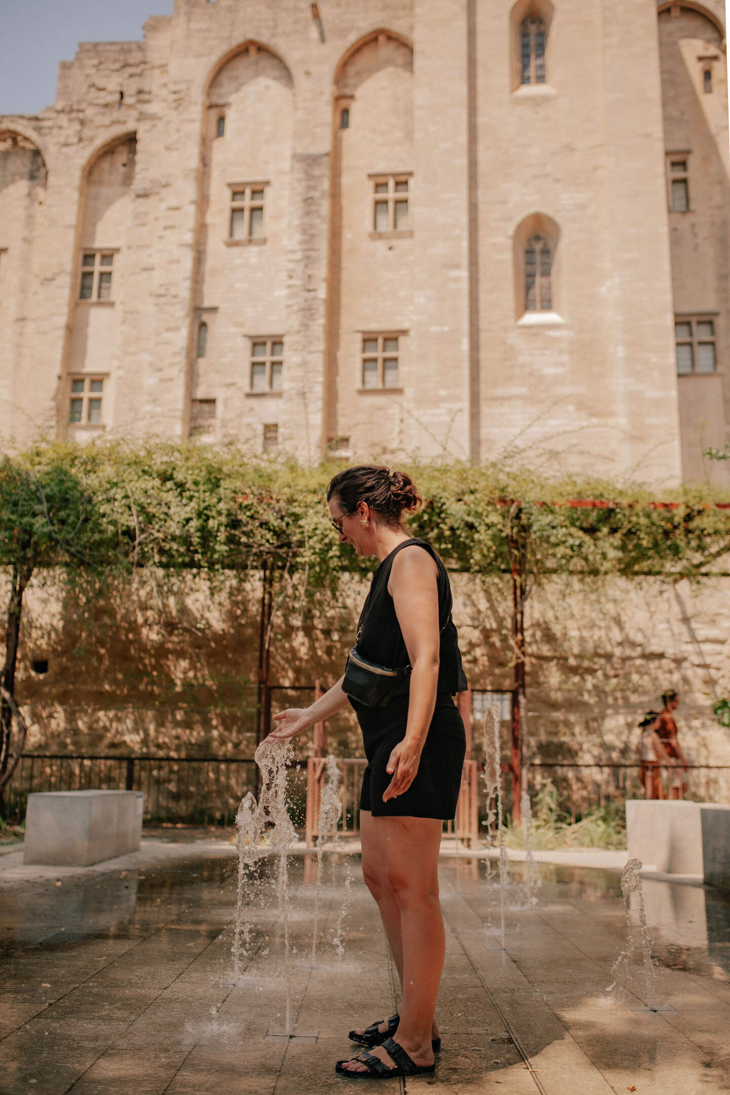 Jolien De Bow refreshes herself at the fountain in Parc des Vergers with the Palais des Papes in the background in Avignon in Vaucluse in Provence in France on July 30, 2026. The scene combines urban nature with one of the city most iconic historic landmarks.
Jolien De Bow se rafraichit a la fontaine du Parc des Vergers avec le Palais des Papes en arriere plan a Avignon dans le Vaucluse en Provence en France le 30 Juillet 2026. La scene associe un espace de nature en ville a un des monuments historiques les plus emblematiques de la cite.