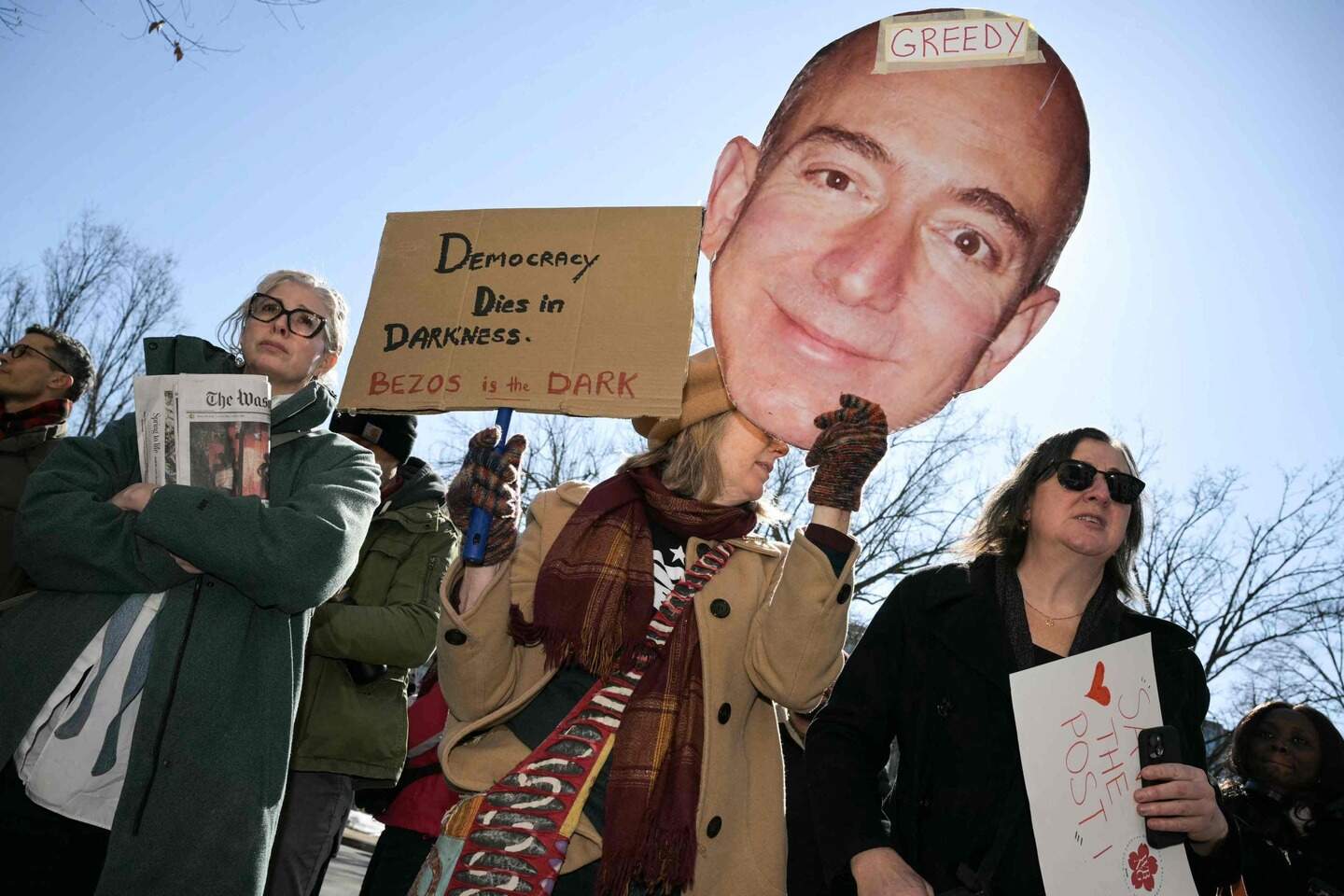 Washington Post employees, along with supporters from the Washington-Baltimore News Guild, rally outside the Washington Post office building in Washington, DC, on Feburary 5, 2026. The Washington Post, owned by billionaire Amazon founder Jeff Bezos, announced major job cuts on February 4, saying that "painful" restructuring was needed at the storied newspaper. The Post, which gained legendary status when its reporting helped bring down president Richard Nixon in the Watergate scandal, will see "substantial" reductions in its newsroom, Executive Editor Matt Murray said. (Photo by Oliver Contreras / AFP)