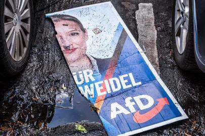 Een poster met de foto van Alice Weidel ligt gescheurd op straat. 