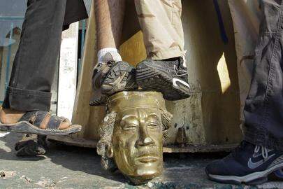 Rebellen vertrappelen het hoofd van Kadhafi’s standbeeld net nadat ze zijn hoofdkwartier in Tripoli hebben ingenomen i(n 2011).