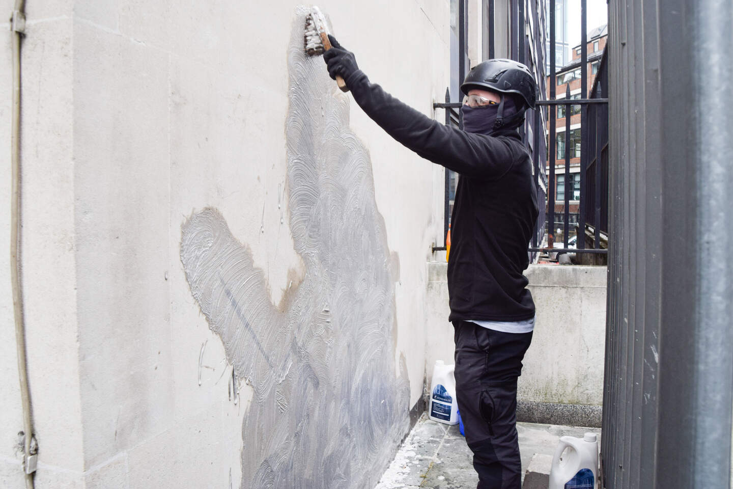 Een kunstwerk van Banksy wordt weggeschrobd.