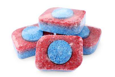 Pile of dishwasher detergent tablets on white background