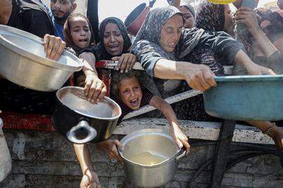 Palestijnen hopen op een warme maaltijd, verdeeld door een liefdadigheidsorganisatie in Gaza-Stad.