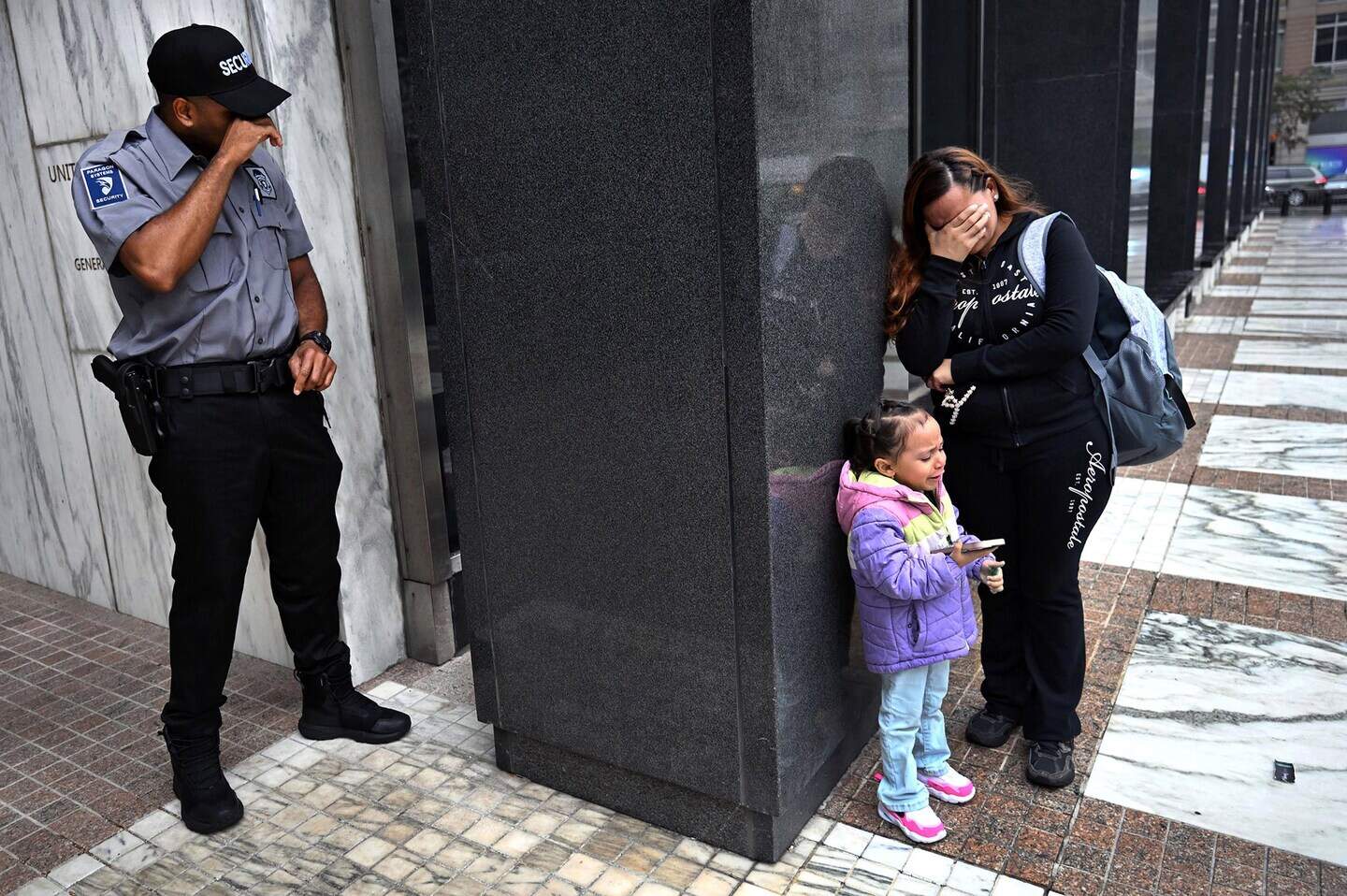 August 20, 2025, New York, New York, USA: A security guard breaks down in tears in a moment of tender humanity while witnessing the heartbreak of a distraught migrant woman and her children after her husband was detained by ICE as they left his immigration court hearing at the Jacob Javits Federal Building in New York. The family was inconsolable with despair. 'Please help me, please help me. Take me too.' she wept as he was led away. Security guards are tangled in the middle of ICE, migrants, observers, activists and press as courthouse dynamics play out in this new normal in America. Sometimes it's the quiet moments that reach most deeply into the collective conscience of a nation. (Credit Image: © Carol Guzy/ZUMA Press Wire)