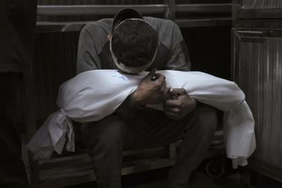 Hossam Azzam met het lichaam van zijn zoontje dat omkwam bij een Israëlische luchtaanval op Gaza. 