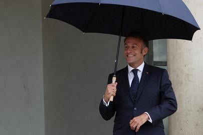 French President Emmanuel Macron holds an umbrella to protect himself from the rain before the arrival of a guest at the Elysee Palace in Paris, France, July 24, 2025. REUTERS/Gonzalo Fuentes     TPX IMAGES OF THE DAY     