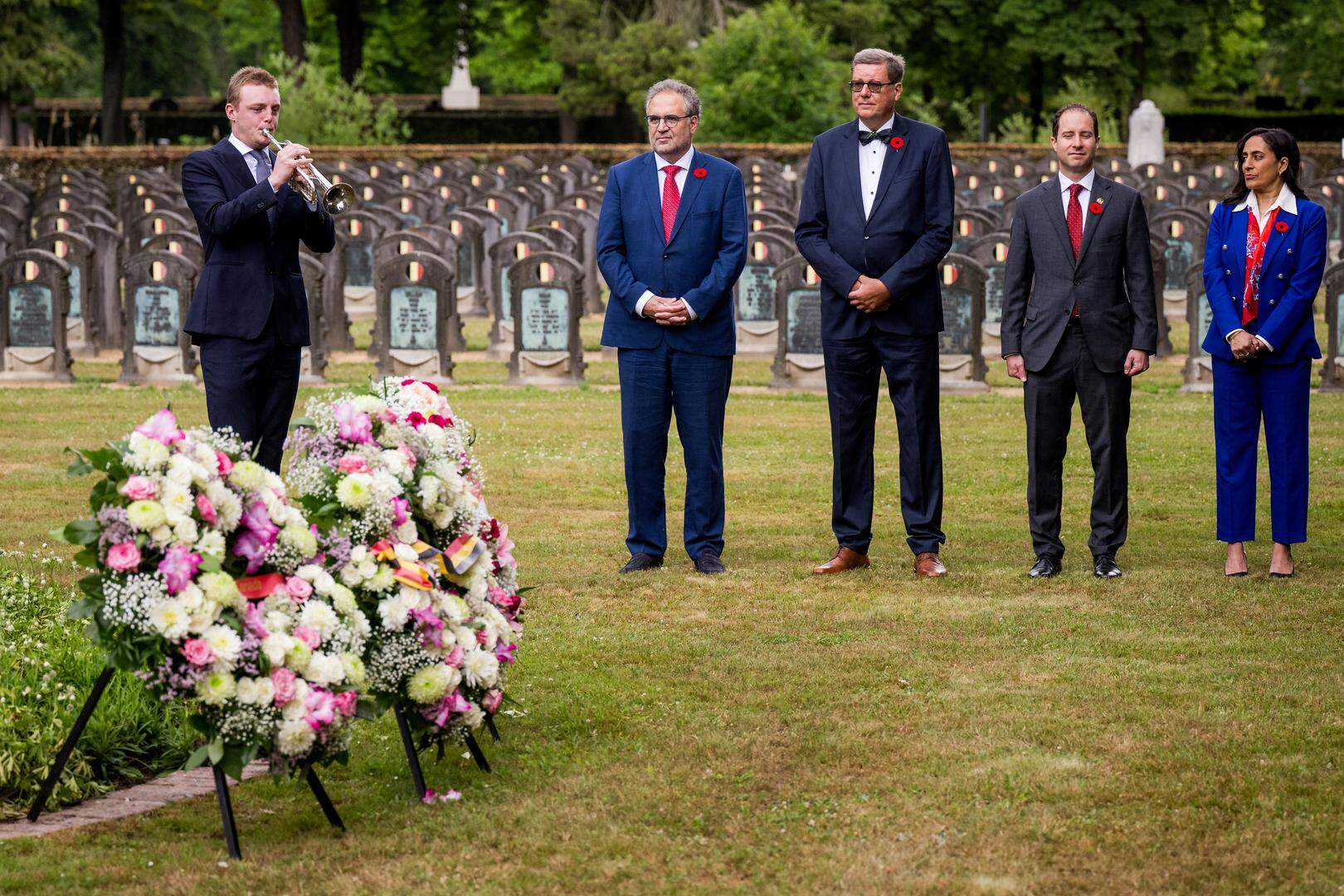 Simon De Wever (L) pictured playing the bugle during a visit to the Schoonselhof cemetary in Antwerp on Monday 23 June 2025, part of a visit of the Canadian head of government to Belgium. BELGA PHOTO JASPER JACOBS