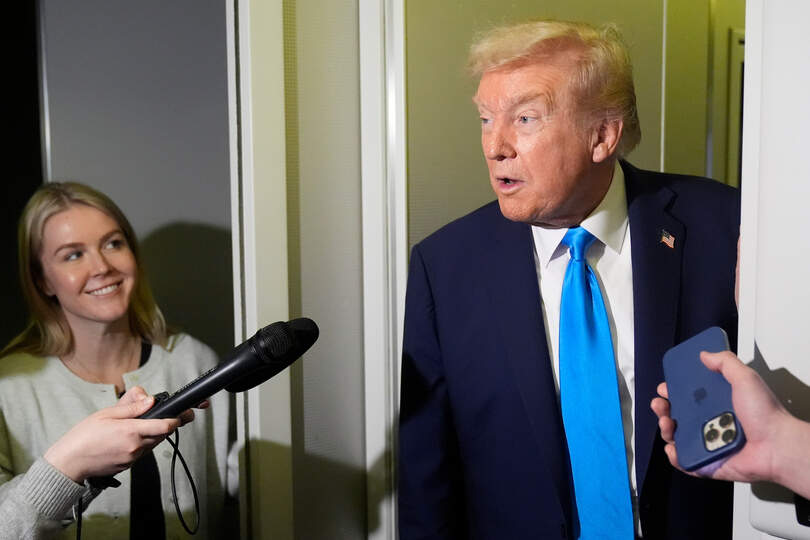 President Donald Trump speaks with reporters as White House press secretary Karoline Leavitt listens aboard Air Force One at Al Udeid Air Base in Doha, Qatar, Saturday, Oct. 25, 2025. (AP Photo/Mark Schiefelbein)