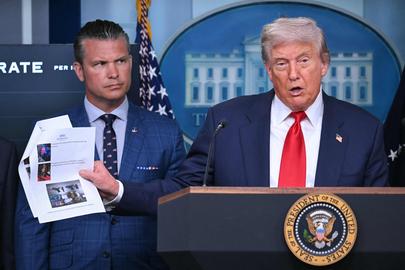 Donald Trump (r.) presenteert zijn plannen voor Washington, geflankeerd door minister van Defensie Pete Hegseth.