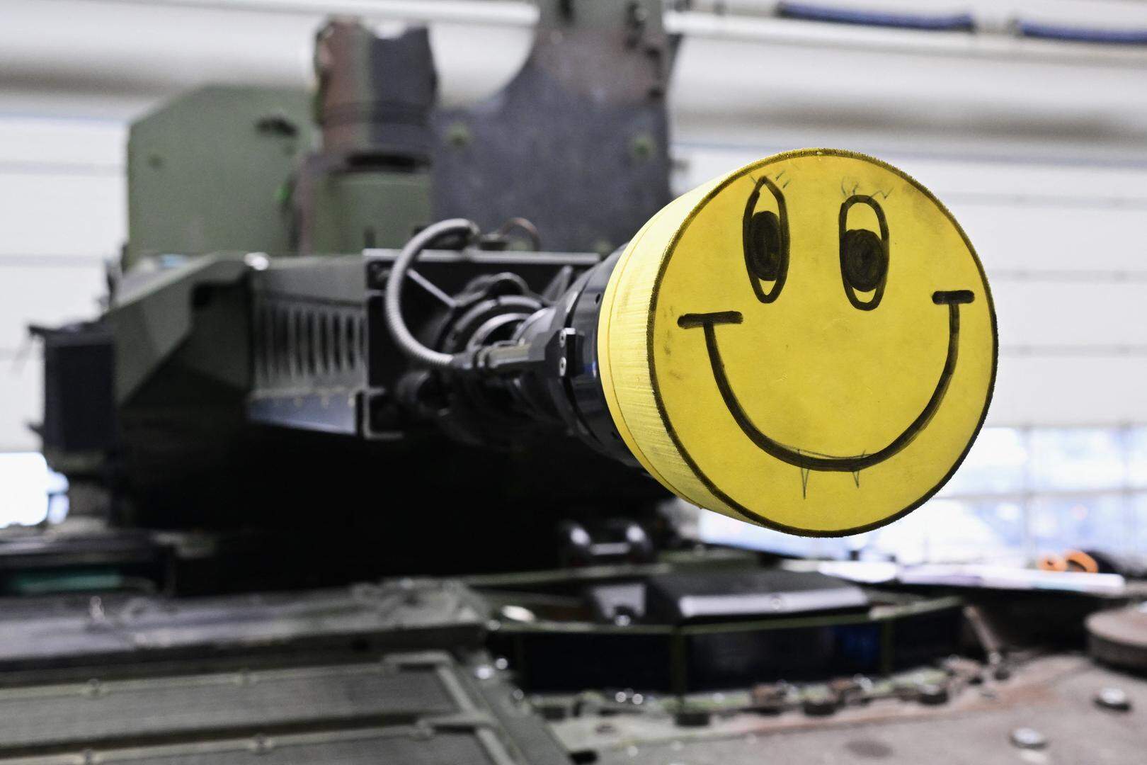 De loop van een tankkanon is afgedekt met een vrolijke dop, tijdens het bezoek van de Duitse bondskanselier op een toekomstige site van wapenfabrikant Rheinmetall begin dit jaar.