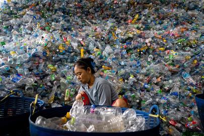 Een arbeidster sorteert plastic afval in Samut Prakan, Thailand. 