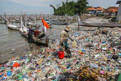 BANGKALAN, INDONESIA - MAY 13: A fisherman arrives at the beach full of rubbish that mostly consists of plastics thrown by local residents and brought by sea currents from various locations in the Kwanyar district, Bangkalan, Madura Island of Indonesia on May 13, 2024. The lack of awareness among residents by throwing rubbish into rivers and seas has resulted in damage to the ecosystem and a decline in fishermen's fish catches around the area. (Photo by Suryanto Suryanto/Anadolu via Getty Images)