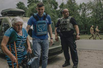 Police collected Lidia Prysiazhena (pictured on a crutch) in an armoured vehicle from her home in the frontline village of Havrylivka in eastern Ukraine. With her is Vitalii x from the Ukrainian evacuation charity Proliska