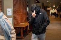 T.L. stak bij het binnenkomen van de rechtbank maandag zijn middenvinger op naar de aanwezige pers.